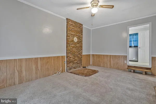a view of an empty room with a chandelier fan