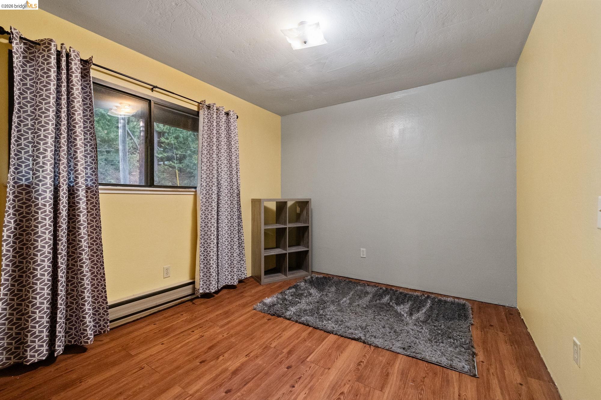 17851 Robin Road Twain Harte, CA 95383 - Photo 16 of 45 Spare room with light wood-style flooring, a baseboard heating unit, and a textured ceiling