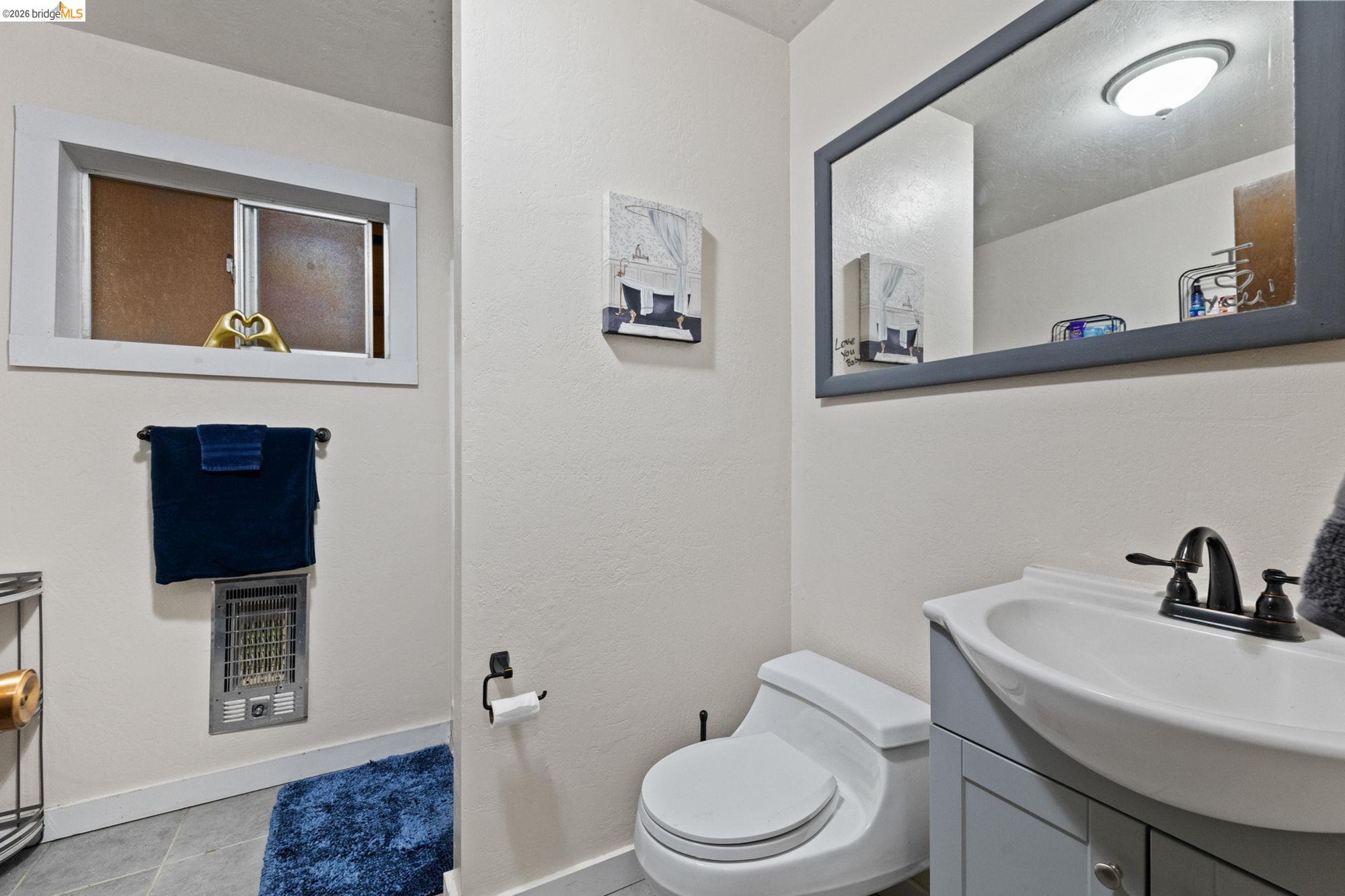 17851 Robin Road Twain Harte, CA 95383 - Photo 26 of 45 Bathroom featuring vanity, heating unit, light tile patterned floors, and a textured ceiling