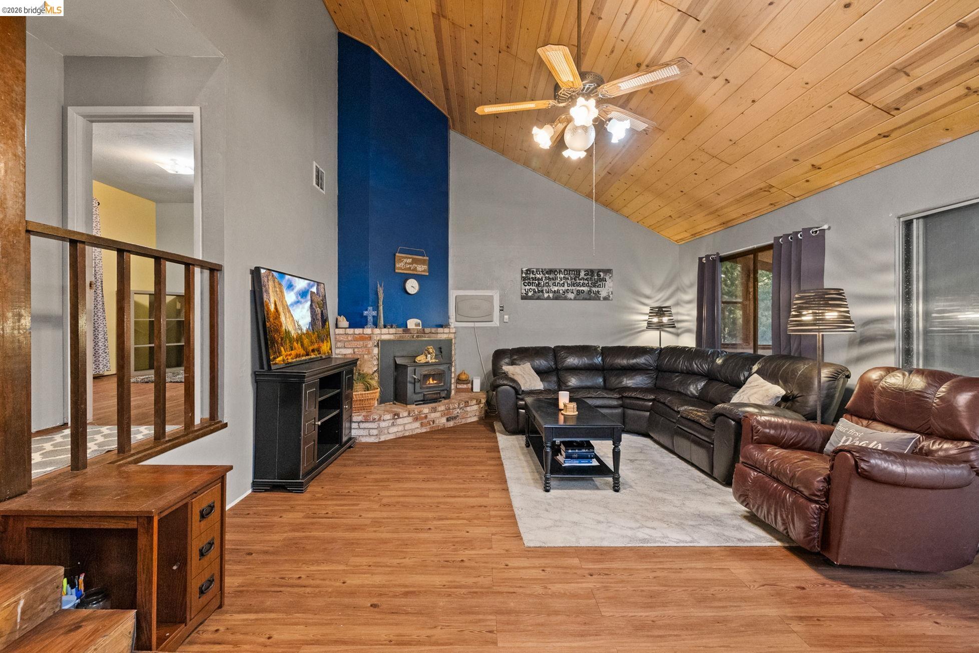 17851 Robin Road Twain Harte, CA 95383 - Photo 5 of 45 Living area featuring a ceiling fan, wood finished floors, a wood stove, and a vaulted wooden ceiling