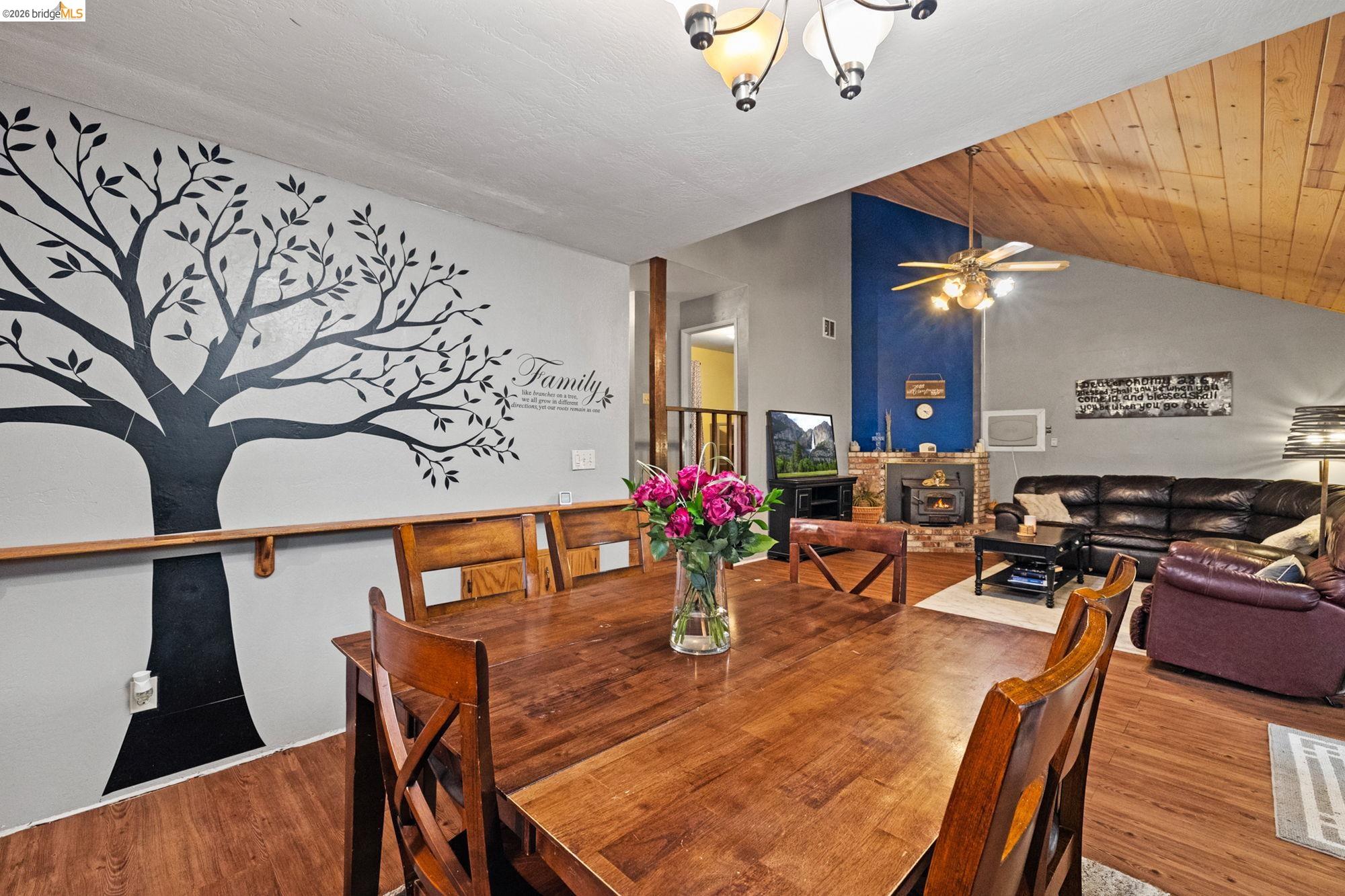 17851 Robin Road Twain Harte, CA 95383 - Photo 10 of 45 Dining room with wood finished floors, a ceiling fan, a chandelier, a vaulted wood ceiling, and a fireplace