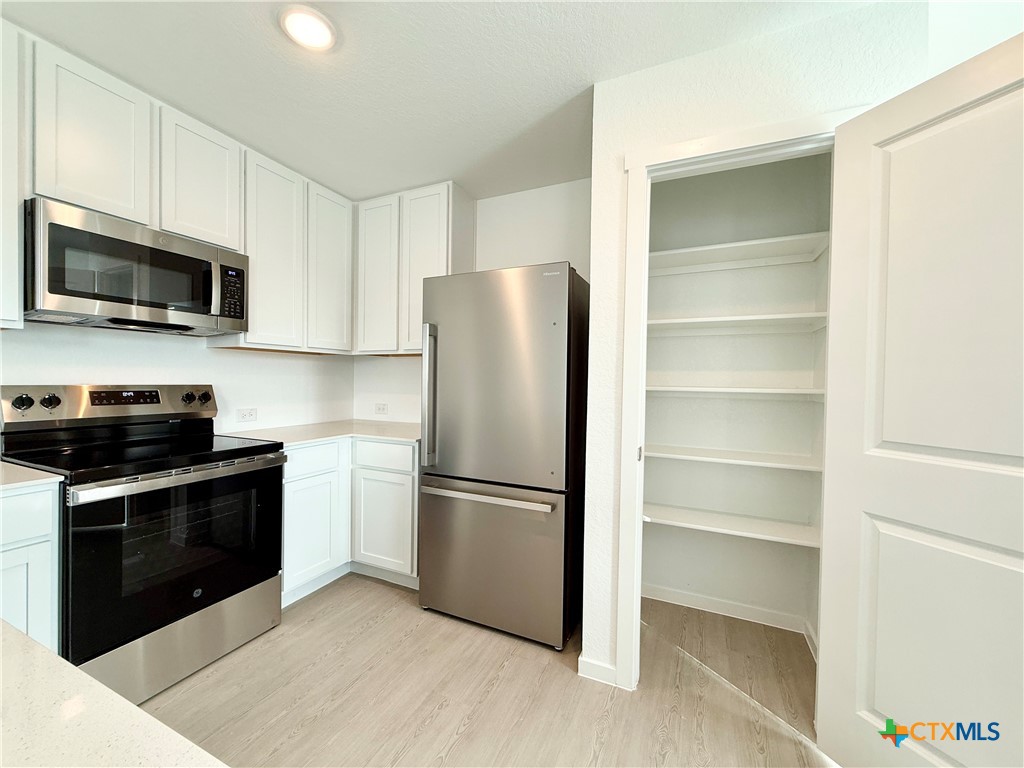 311 Moscato Road New Braunfels, TX 78130 - Photo 7 of 38 a kitchen with a refrigerator stove and microwave