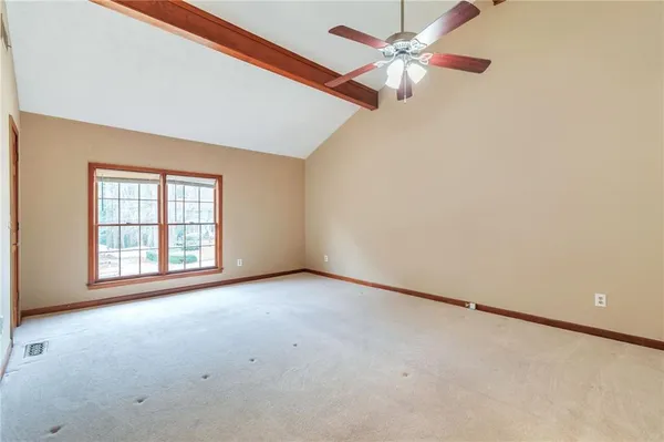 an empty room with a window and a fan