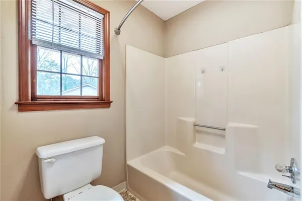 a white toilet sitting next to a bath tub