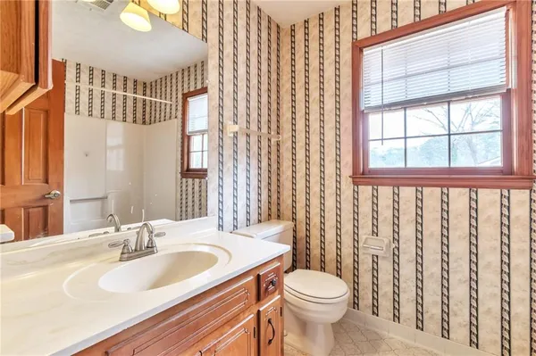 a bathroom with a sink a toilet and a mirror