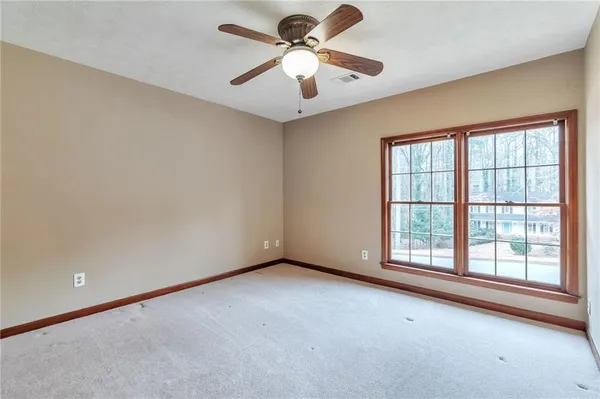 an empty room with windows and fan