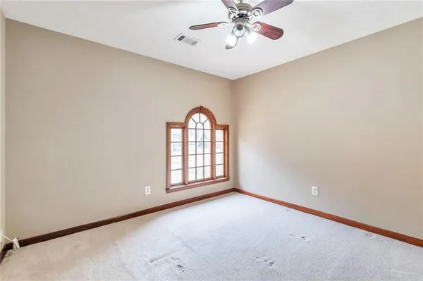 an empty room with windows and fan