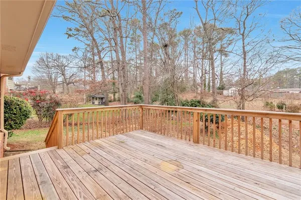 a balcony with wooden floor and trees