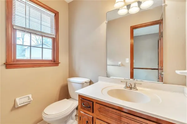 a bathroom with a toilet a sink a mirror and vanity