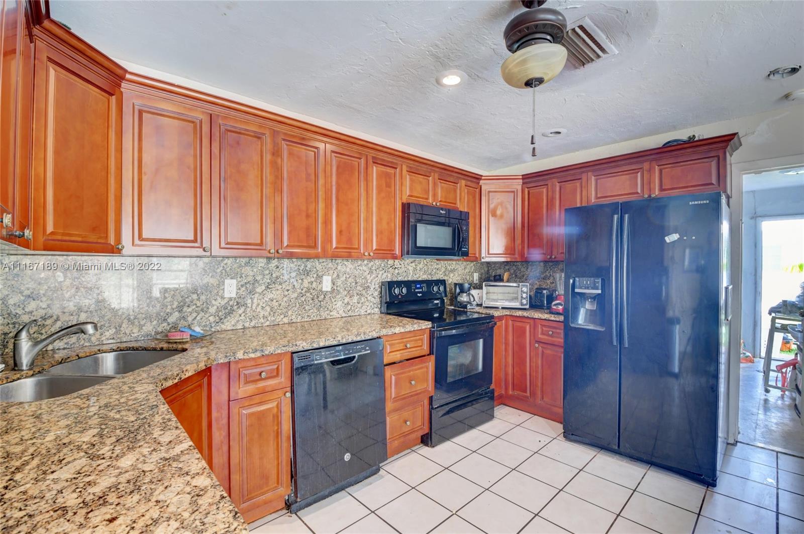 1945 North Conference Drive Boca Raton, FL 33486 - Photo 11 of 19 a kitchen with stainless steel appliances granite countertop a sink dishwasher stove top oven and cabinets
