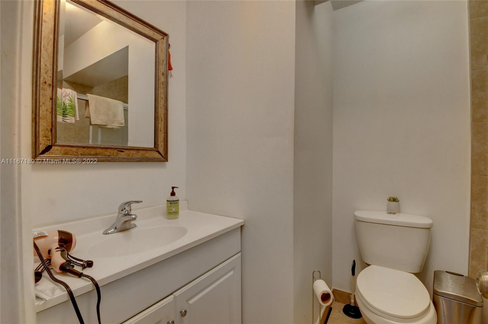 1945 North Conference Drive Boca Raton, FL 33486 - Photo 13 of 19 a white toilet sitting next to a bathroom sink