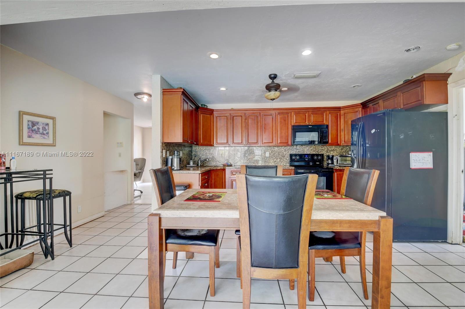 1945 North Conference Drive Boca Raton, FL 33486 - Photo 10 of 19 a kitchen with stainless steel appliances granite countertop a table and chairs