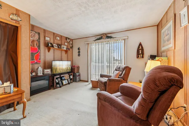 a living room with furniture a flat screen tv and a window