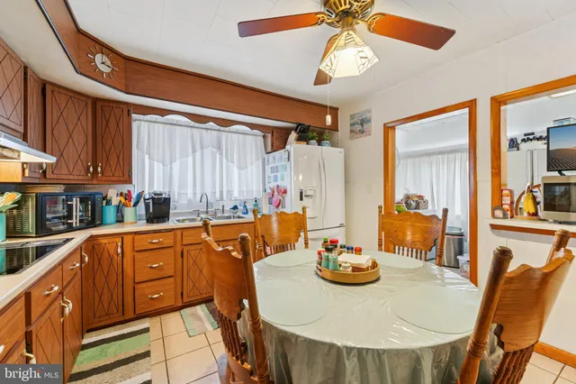 a kitchen with stainless steel appliances granite countertop a stove a sink dishwasher and a dining table with the kitchen view