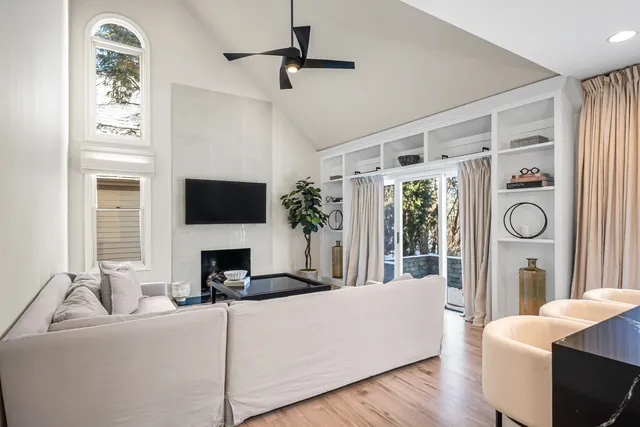 a living room with furniture a fireplace and a flat screen tv