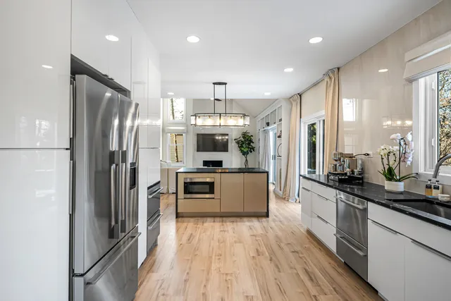 a large kitchen with stainless steel appliances a refrigerator and a stove top oven