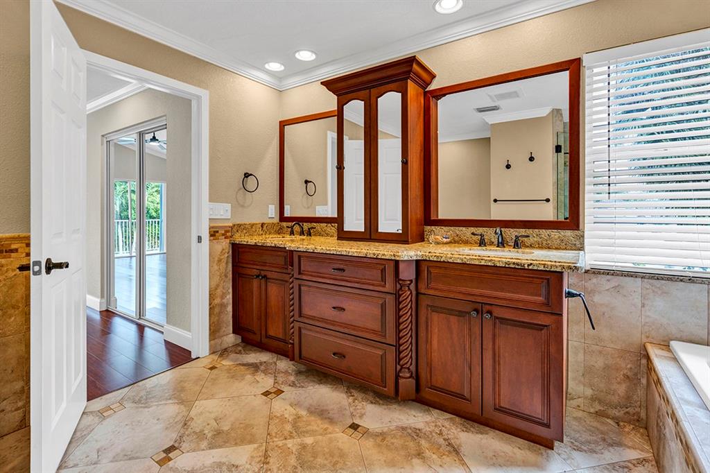 19571 Black Olive Lane Boca Raton, FL 33498 - Photo 28 of 61 a spacious bathroom with a granite countertop sink and a mirror