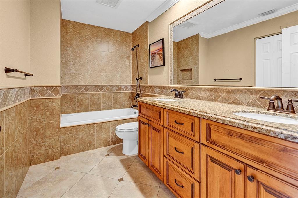 19571 Black Olive Lane Boca Raton, FL 33498 - Photo 29 of 61 a bathroom with a granite countertop sink a mirror a bathtub and next to a window
