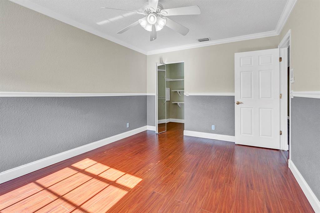 19571 Black Olive Lane Boca Raton, FL 33498 - Photo 31 of 61 an empty room with wooden floor chandelier fan and windows