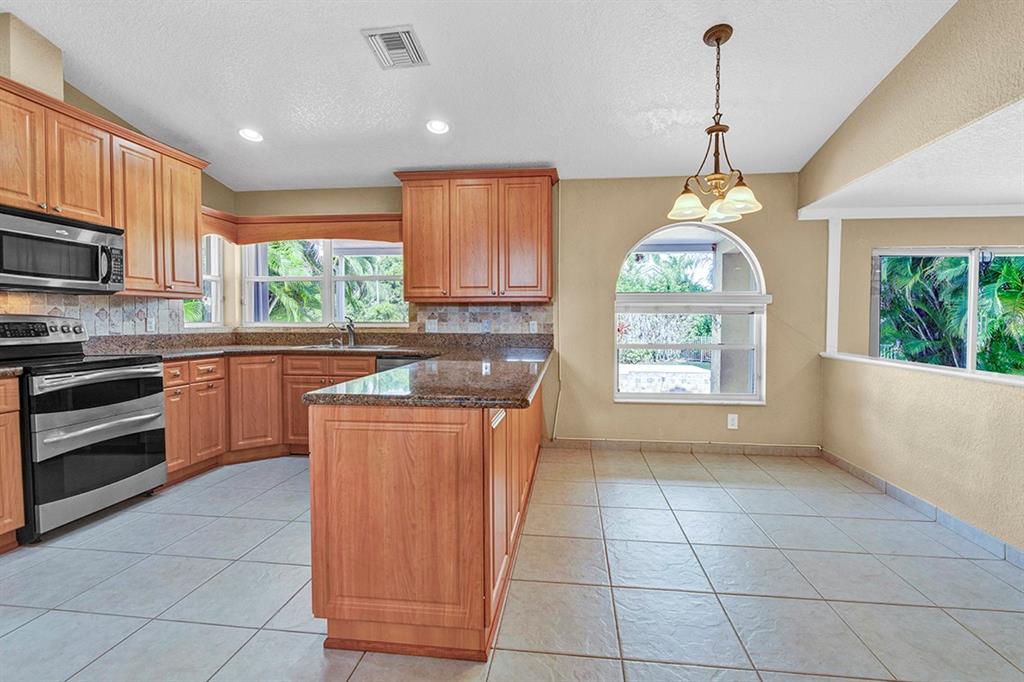 19571 Black Olive Lane Boca Raton, FL 33498 - Photo 39 of 61 a kitchen with stainless steel appliances a stove sink and microwave