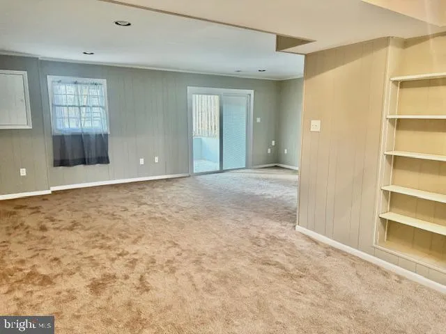 an empty room with windows and cabinet