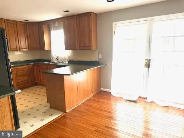 a kitchen with granite countertop wooden cabinets and wooden floor