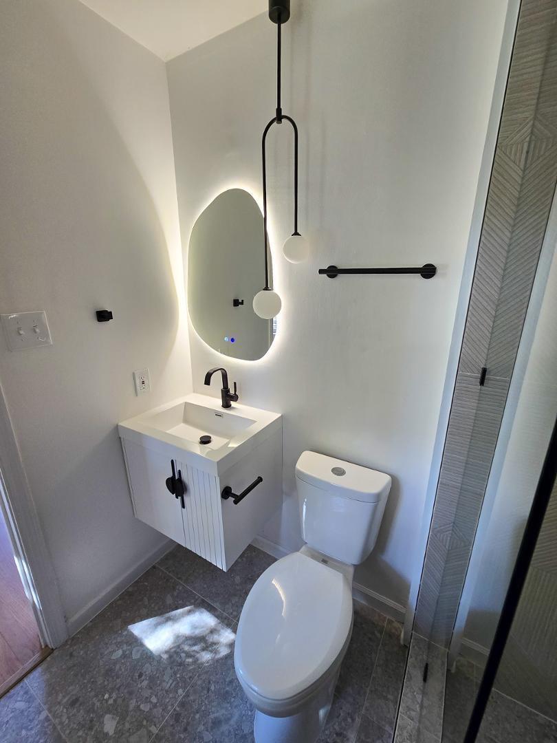 1105 Hardimont Road Raleigh, NC 27609 - Photo 23 of 61 a bathroom with a toilet sink and mirror