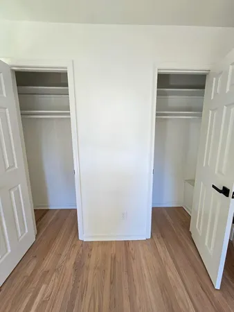 an empty room with wooden floor and window