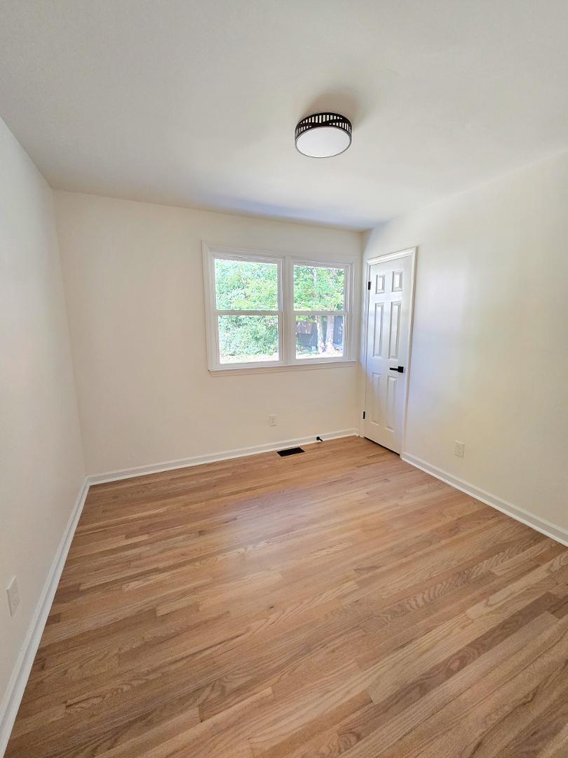 1105 Hardimont Road Raleigh, NC 27609 - Photo 29 of 61 an empty room with wooden floor and windows