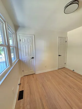an empty room with wooden floor and closet