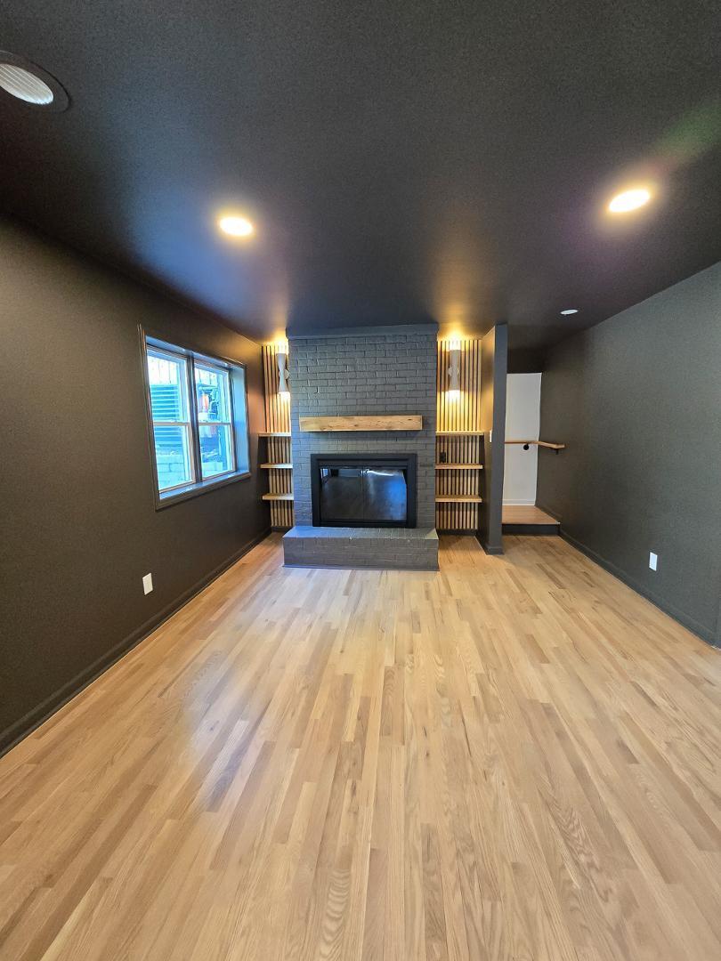 1105 Hardimont Road Raleigh, NC 27609 - Photo 44 of 61 an empty room with a fireplace and wooden floor