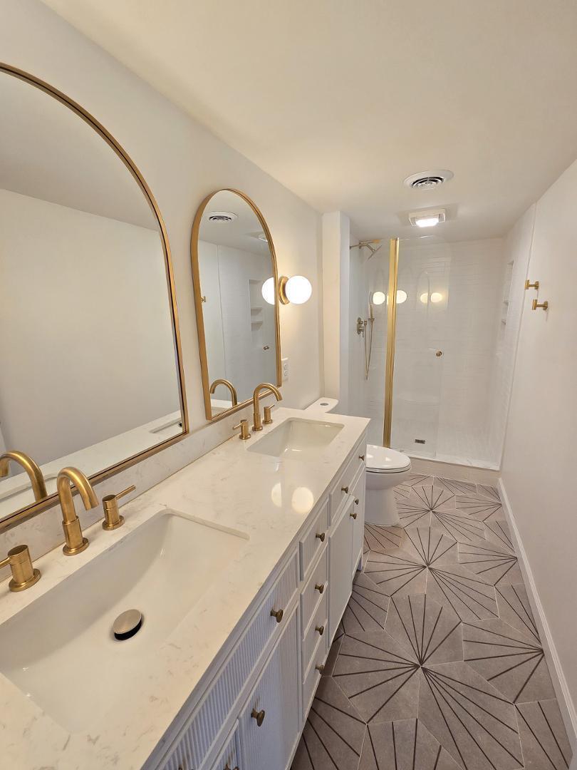 1105 Hardimont Road Raleigh, NC 27609 - Photo 49 of 61 a bathroom with a granite countertop sink a large mirror and shower