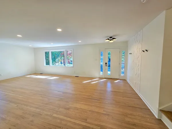a large kitchen with kitchen island a stove a sink dishwasher and wooden floor