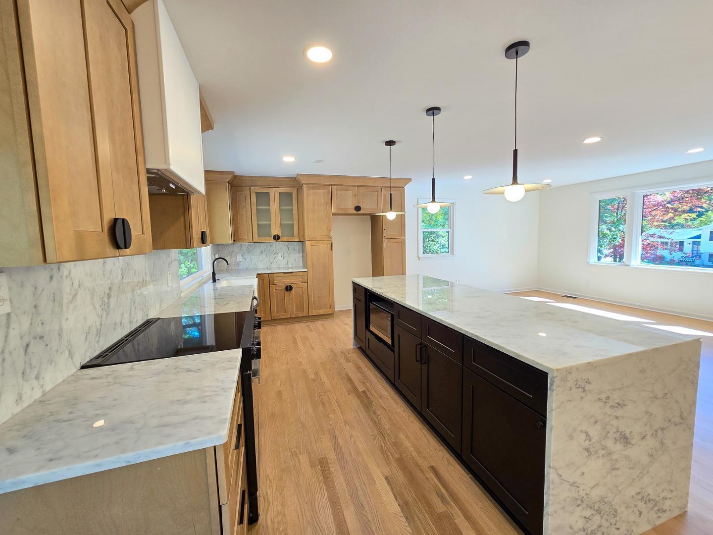 1105 Hardimont Road Raleigh, NC 27609 - Photo 10 of 61 a large kitchen with kitchen island a large counter top space a sink stainless steel appliances and cabinets