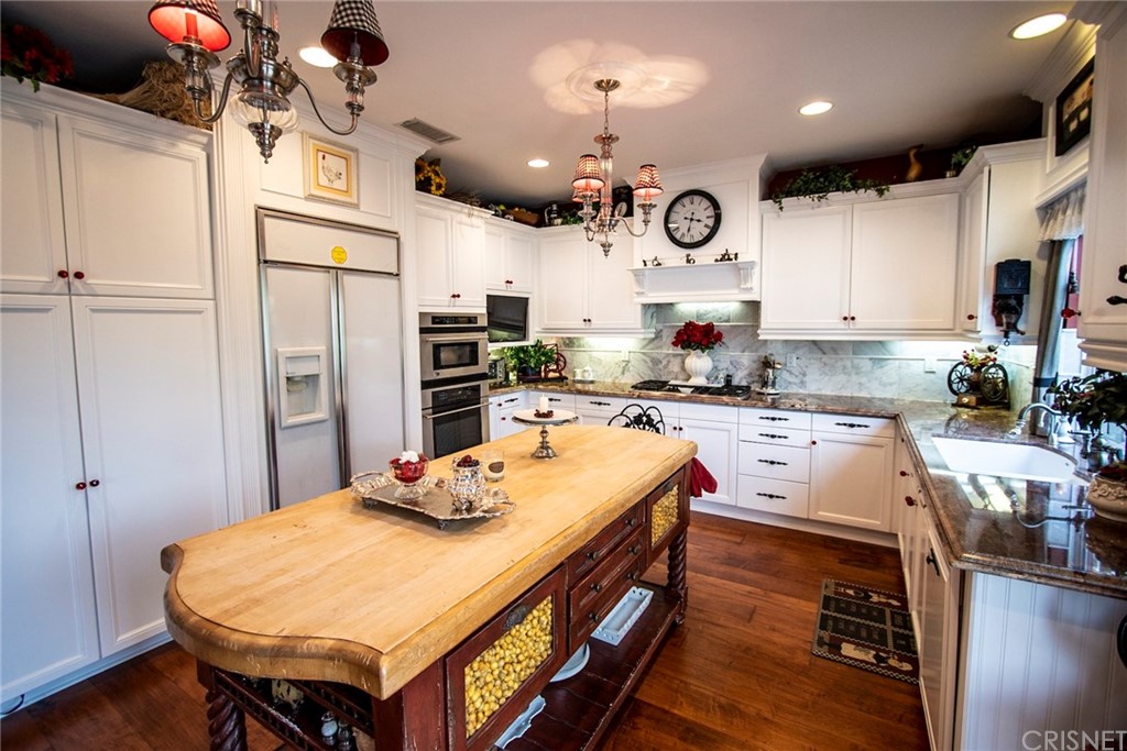27016 Island Road Valencia, CA 91355 - Photo 23 of 53 a kitchen with stainless steel appliances granite countertop a sink refrigerator and cabinets
