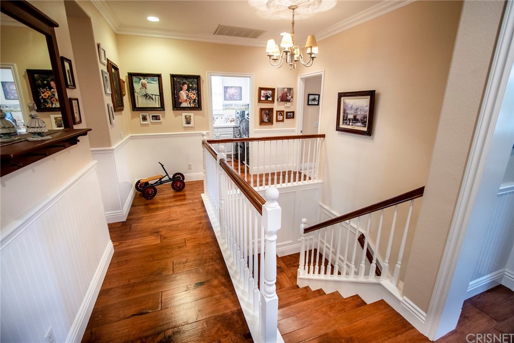 27016 Island Road Valencia, CA 91355 - Photo 32 of 53 a view of a hallway with wooden floor and staircase