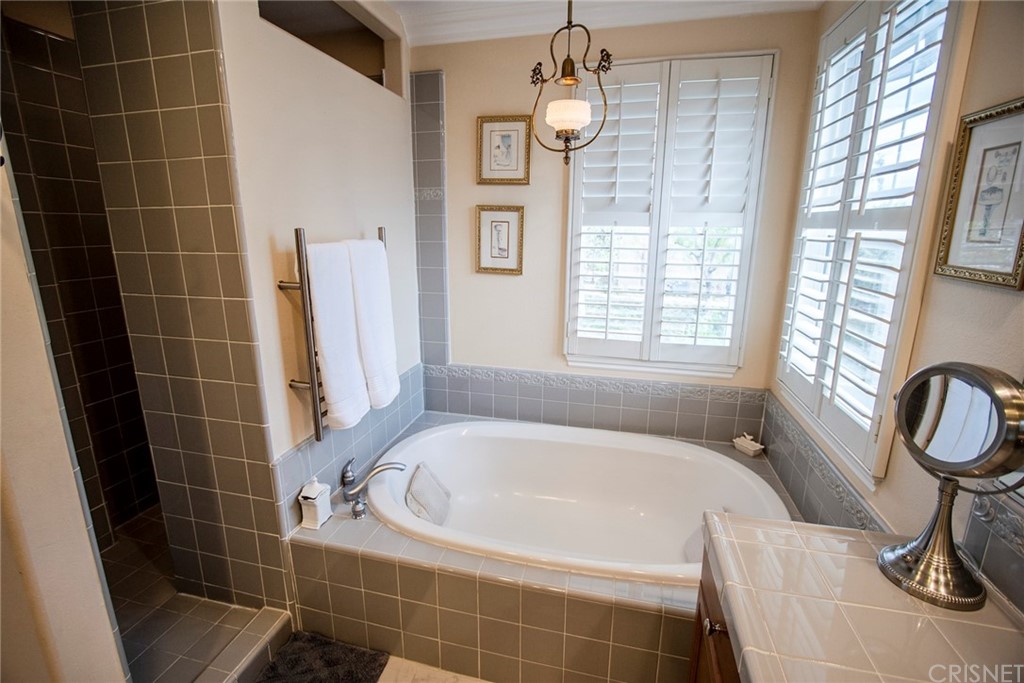 27016 Island Road Valencia, CA 91355 - Photo 49 of 53 a bathroom with a tub a window and a shower