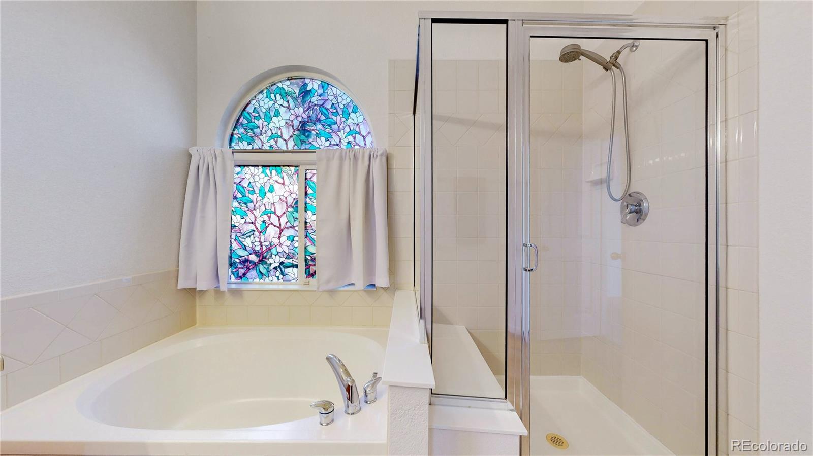 12237 Cook Court Thornton, CO 80241 - Photo 19 of 48 a bathroom with a bathtub and shower