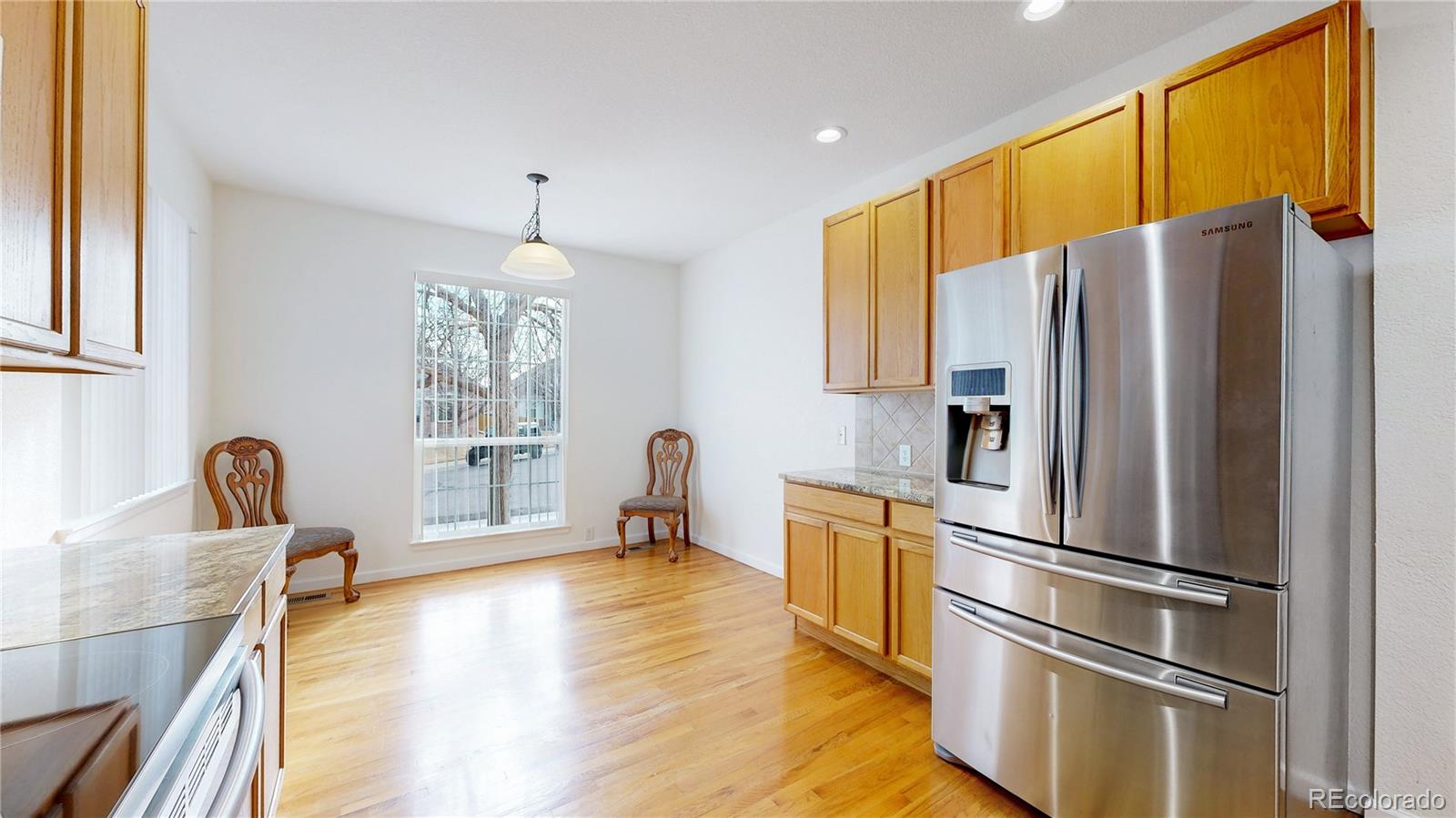 12237 Cook Court Thornton, CO 80241 - Photo 8 of 48 a kitchen with stainless steel appliances a refrigerator and wooden floor