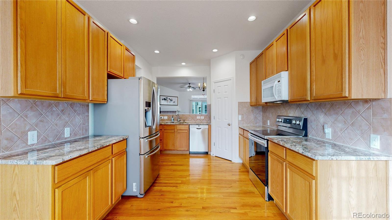 12237 Cook Court Thornton, CO 80241 - Photo 10 of 48 a kitchen with stainless steel appliances granite countertop wooden cabinets a sink and dishwasher a stove top oven