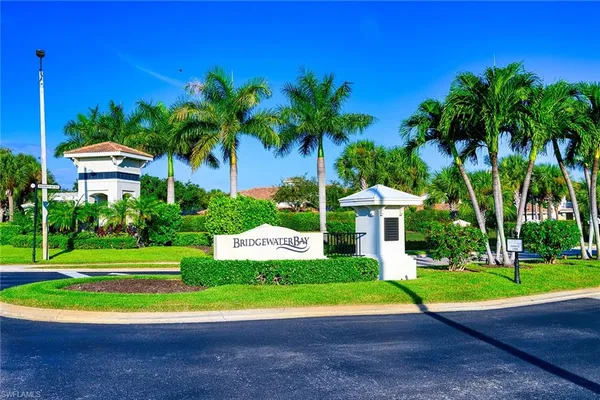 a view of a house with a yard and palm trees