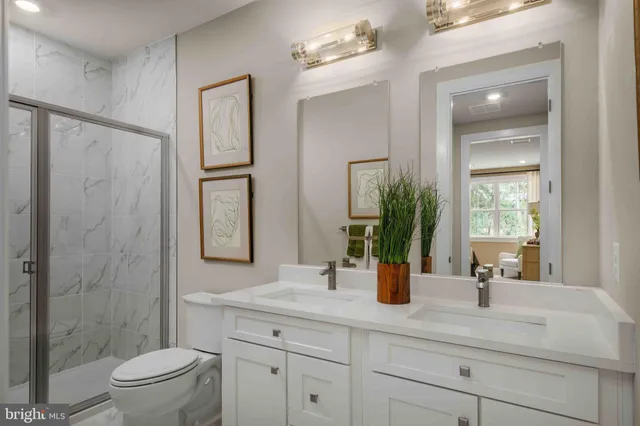 a bathroom with a double vanity sink toilet and shower