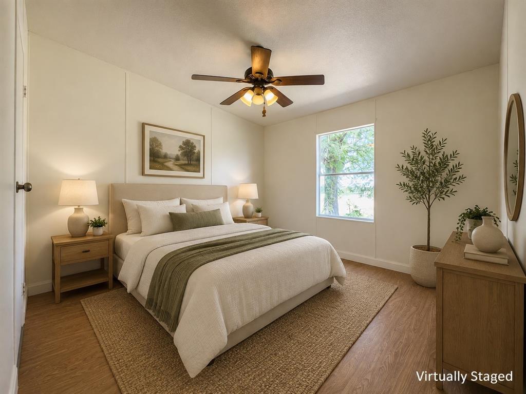 18327 Gholson Road Waco, TX 76705 - Photo 9 of 19 Wood-finish flooring, an upholstered headboard, a ceiling fan with integrated lighting, and a window with natural light