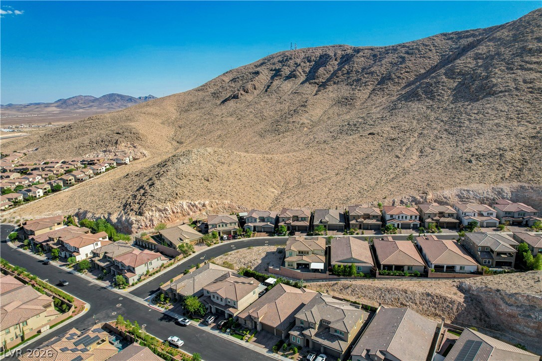 3943 Reyes Avenue Las Vegas, NV 89141 - Photo 73 of 95 An aerial perspective reveals a desert community nestled at the base of a majestic mountain range.
