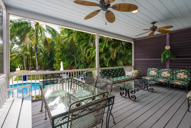 a balcony with wooden floor and outdoor seating