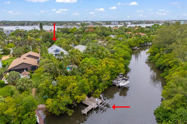 an aerial view of a house with a yard and lake view