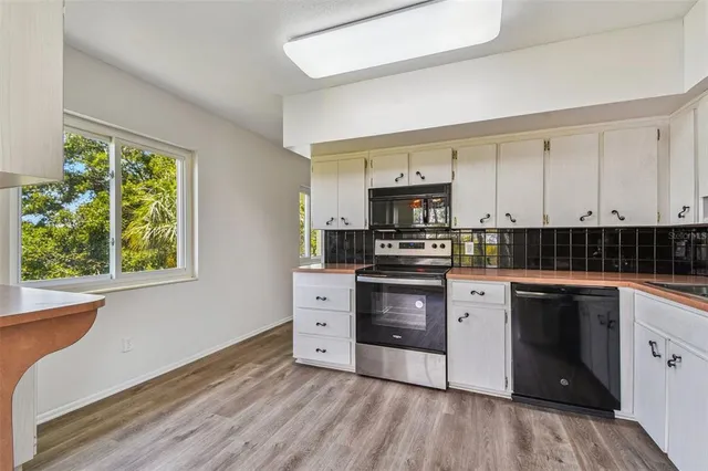 a kitchen with white cabinets and stainless steel appliances
