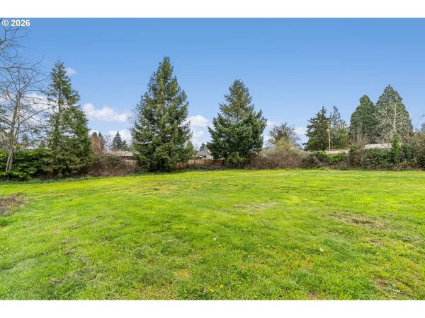 a view of a backyard with wooden fence and a table