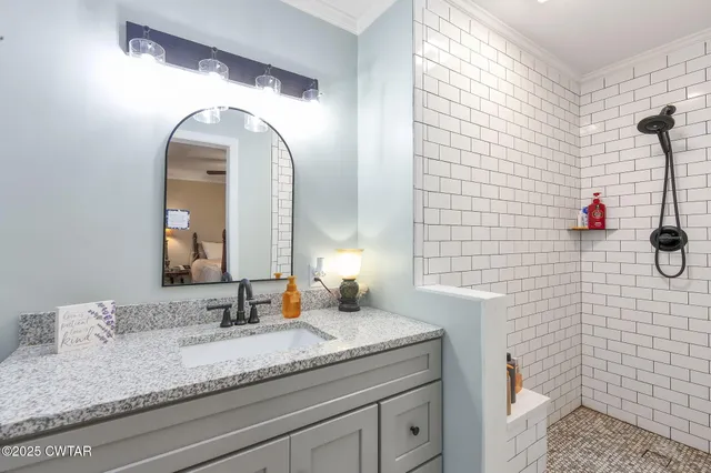 a bathroom with a granite countertop sink a toilet and a mirror