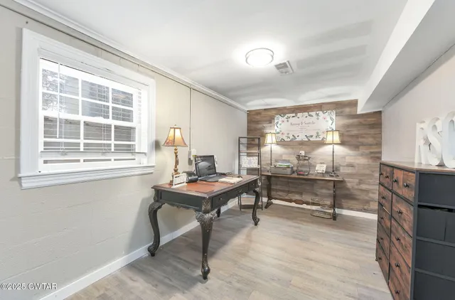 a view of a workspace with furniture window and wooden floor
